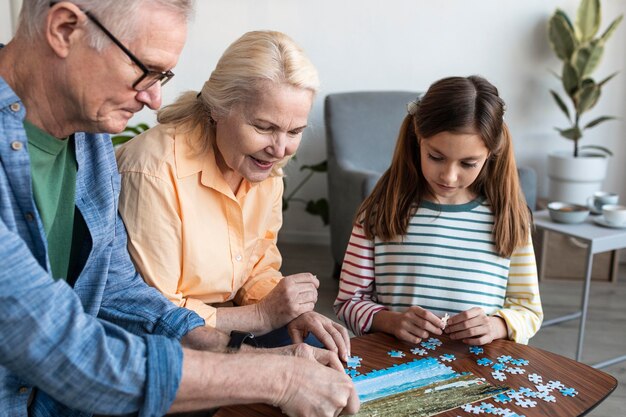 Dziadkowie i dziewczyna robi puzzle z bliska
