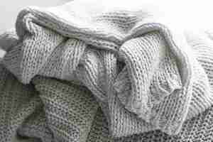 Bezpłatne zdjęcie dzianinowy ciepły szary sweterek lub szalik przytulna kompozycja w domowej atmosferze