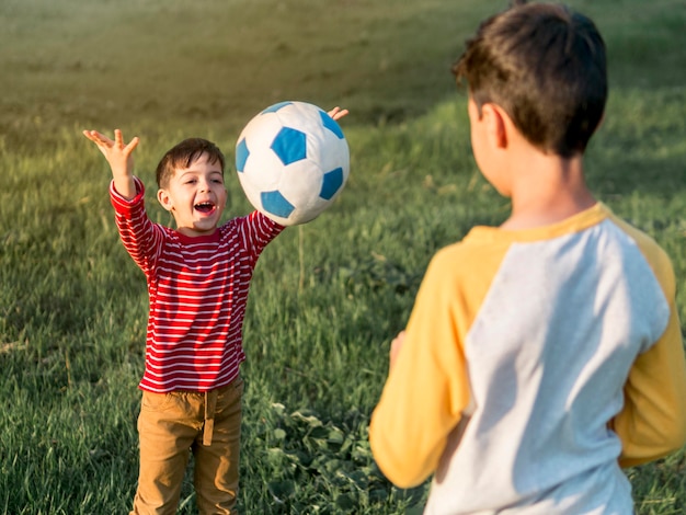 Dzieci bawiące się piłką na świeżym powietrzu