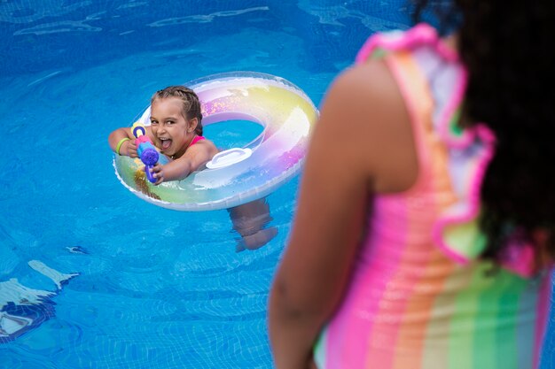 Dzieci bawiące się pływakiem na basenie