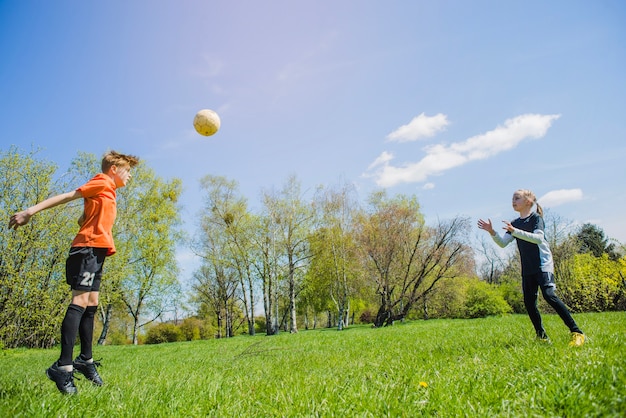 Bezpłatne zdjęcie dzieci bawiące soccer w parku