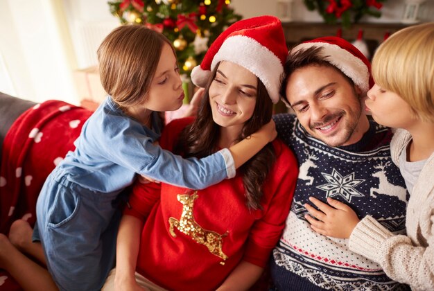 Dzieci całują swoich rodziców na Boże Narodzenie