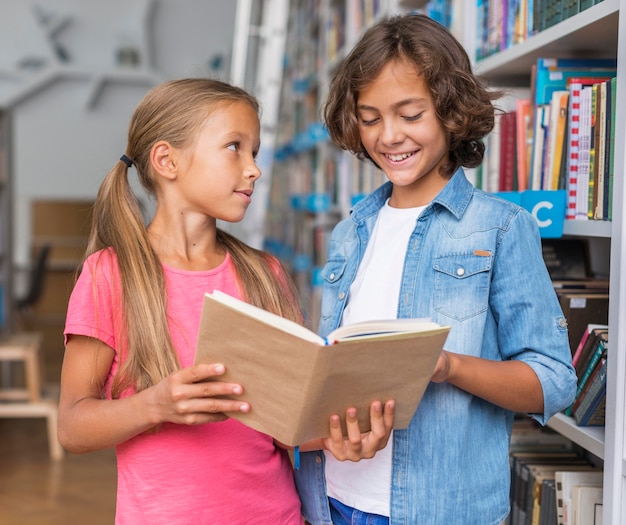 Dzieci czytające książkę w bibliotece