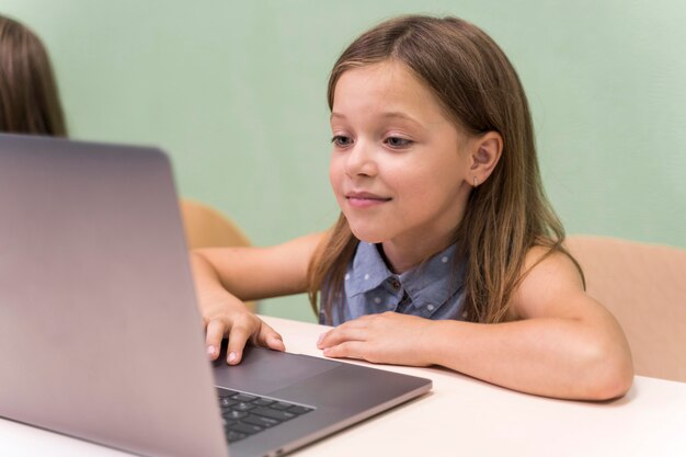 Dzieci korzystające z laptopa w szkole