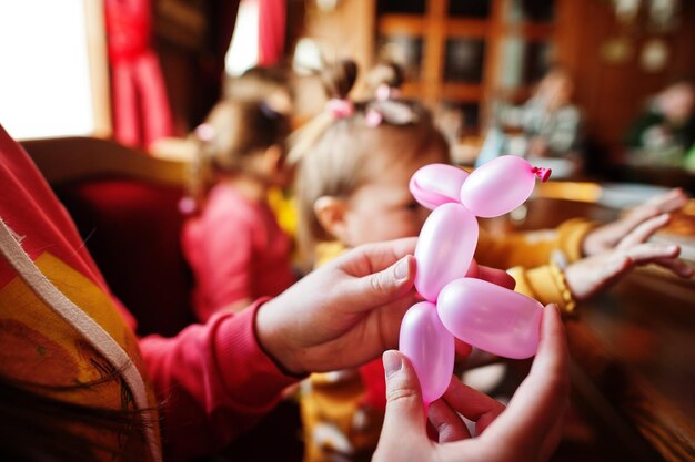 Dzieci na przyjęciu urodzinowym robią balony ze zwierzętami
