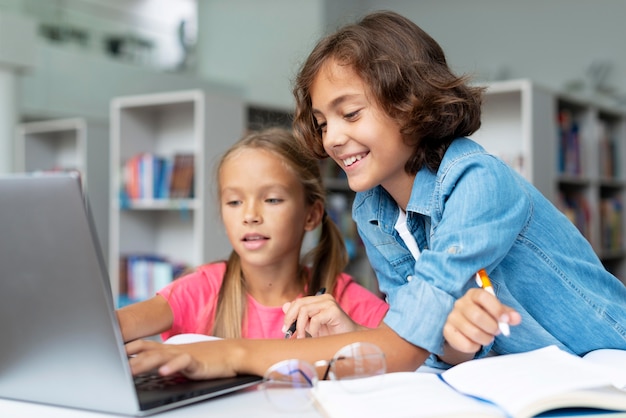 Dzieci odrabiają lekcje na laptopie