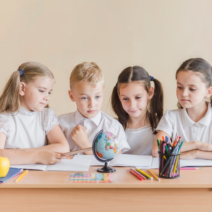 Bezpłatny plik Zdjęcie dzieci patrzące na globus w szkole