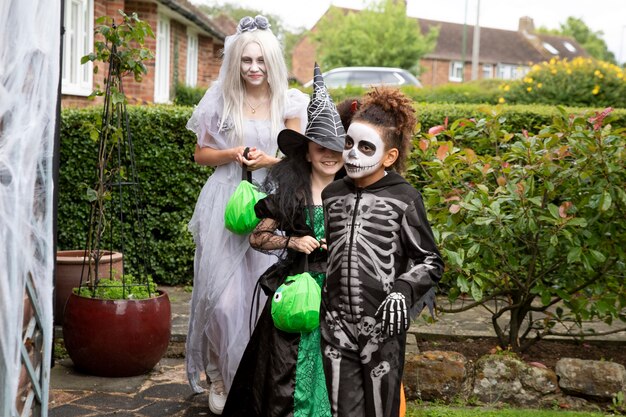 Dzieci w kostiumach oszukują lub traktują na Halloween
