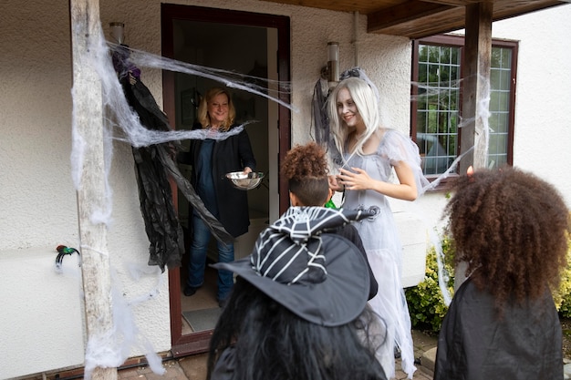 Dzieci w kostiumach oszukują lub traktują na Halloween