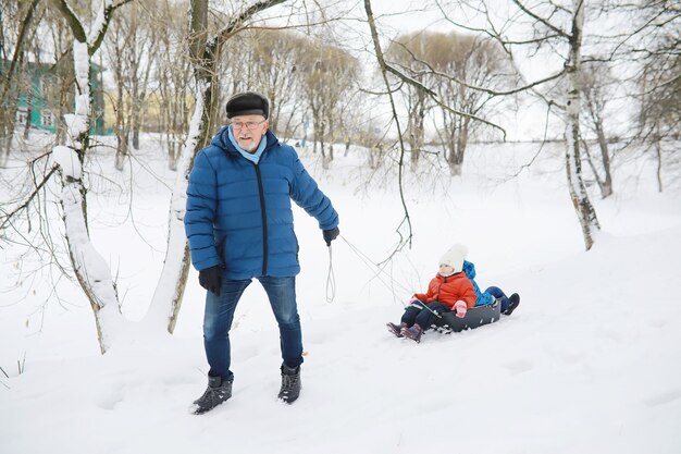 Dzieci w parku zimą. dzieci bawią się śniegiem na placu zabaw. rzeźbią bałwany i zjeżdżają ze wzgórz.