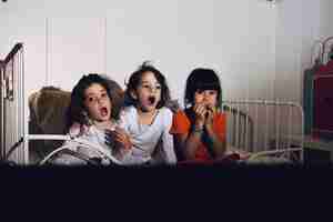 Bezpłatne zdjęcie dzieci w sypialni oglądając horror