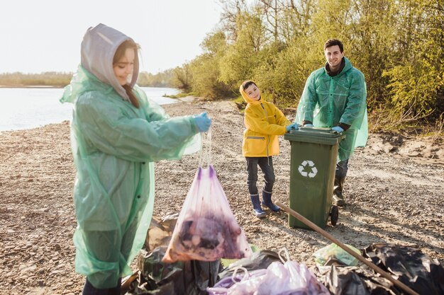 Dzieci zbierają worki na śmieci w lesie