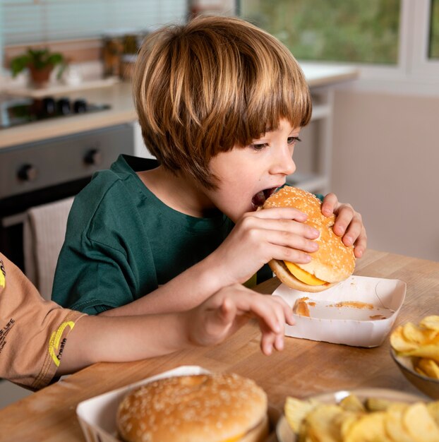 Dzieciak jedzący burgera w domu