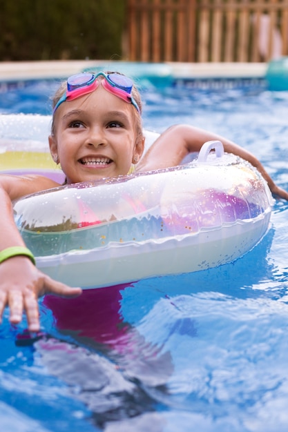 Bezpłatne zdjęcie dziecko bawiące się z pływakiem na basenie