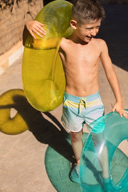 Bezpłatne zdjęcie dziecko bawiące się z pływakiem przy basenie