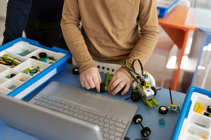 Bezpłatny plik Zdjęcie dziecko budujące robota przy użyciu części elektronicznych