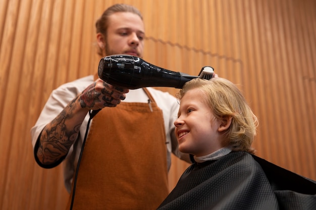 Bezpłatne zdjęcie dziecko dostaje dmuchane włosy w salonie