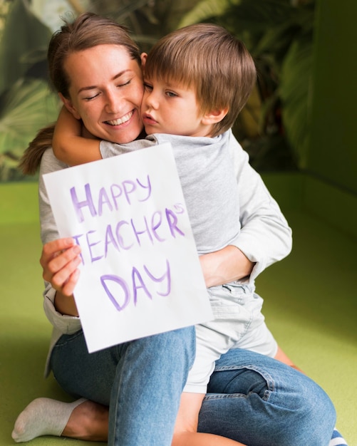 Bezpłatne zdjęcie dziecko przytulanie szczęśliwego nauczyciela