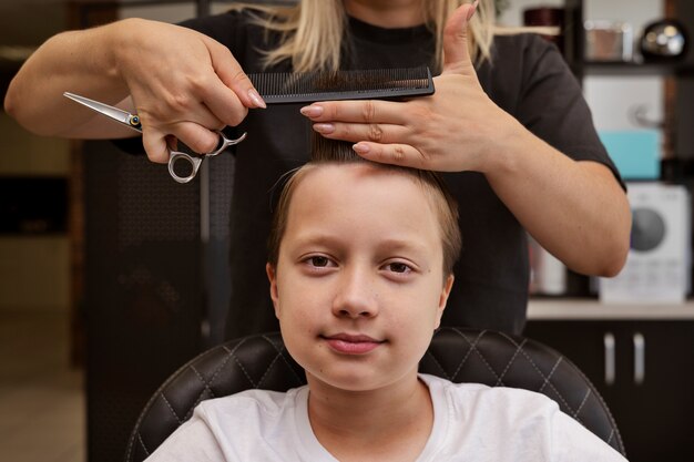 Dziecko robi fryzurę w widoku z przodu salonu