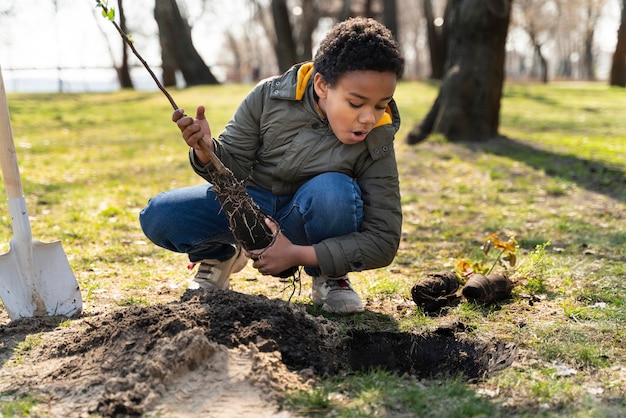 Dziecko uczy się, jak sadzić drzewo