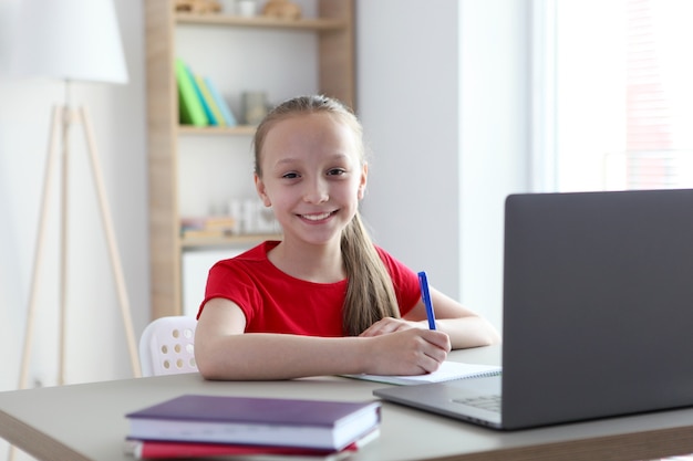 Dziecko uczy się online w domu za pomocą nowoczesnego laptopa w internecie
