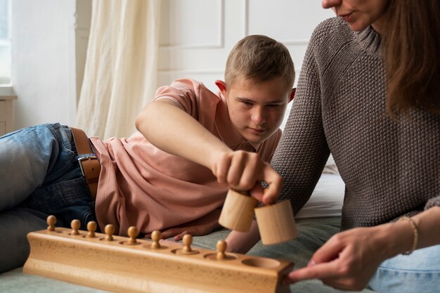 Dziecko z widokiem z przodu bawiące się drewnianą zabawką