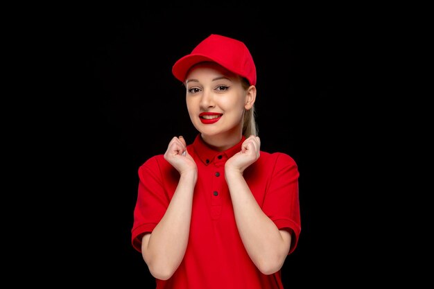 Dzień czerwonej koszuli podekscytowana dziewczyna uśmiechająca się z pięściami w czerwonej czapce, ubrana w koszulę i jasną szminkę