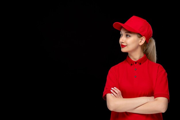 Dzień czerwonej koszuli uśmiechnięta dziewczyna ze skrzyżowanymi rękami w czerwonej czapce, ubrana w koszulę i jasną szminkę