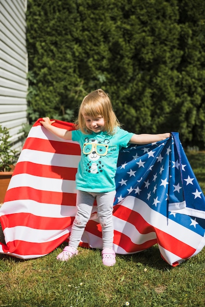 Bezpłatne zdjęcie dzień niepodległości pojęcie z dziewczyną w ogródzie