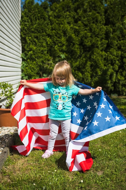 Bezpłatne zdjęcie dzień niepodległości pojęcie z dziewczyną w ogródzie