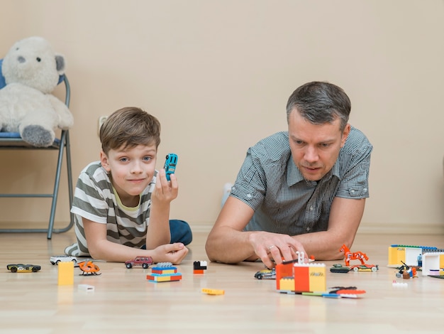 Bezpłatne zdjęcie dzień ojca tata i syn bawią się klockami lego