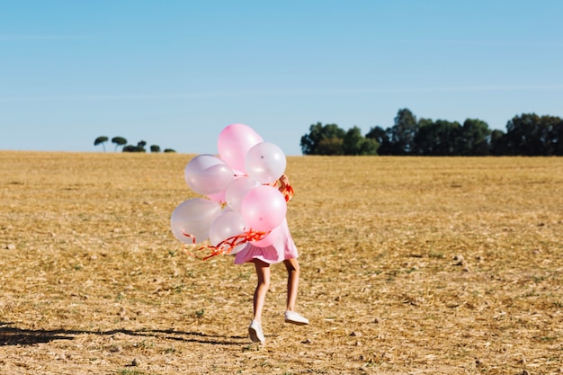 Bezpłatne zdjęcie dziewczyna bieg z wiązką balony