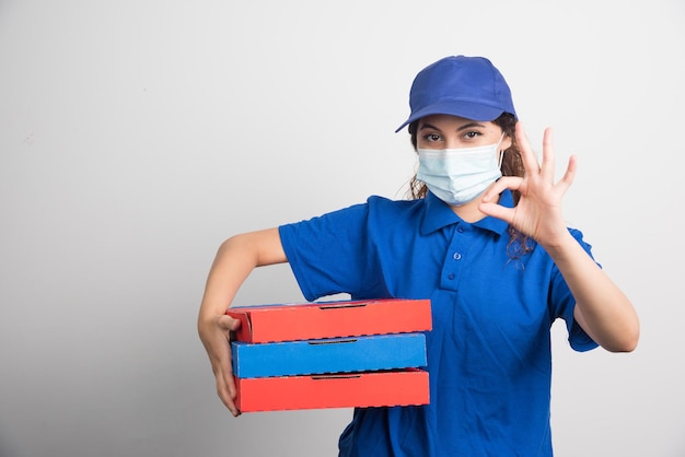 Dziewczyna Dostarczająca Pizzę Trzymająca Trzy Pudełka Z Maseczką Medyczną I Pokazująca Ok Gest Na Białym Tle