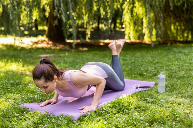 Dziewczyna fitness pompowania prasy na świeżym powietrzu w parku