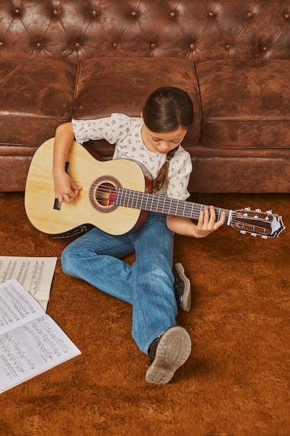 Bezpłatne zdjęcie dziewczyna gra na gitarze w domu