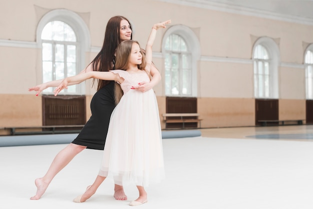 Dziewczyna i baletnica nauczyciel taniec razem w studio tańca