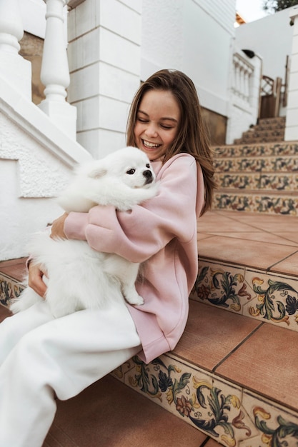 Bezpłatne zdjęcie dziewczyna i puszysty pies na schodach