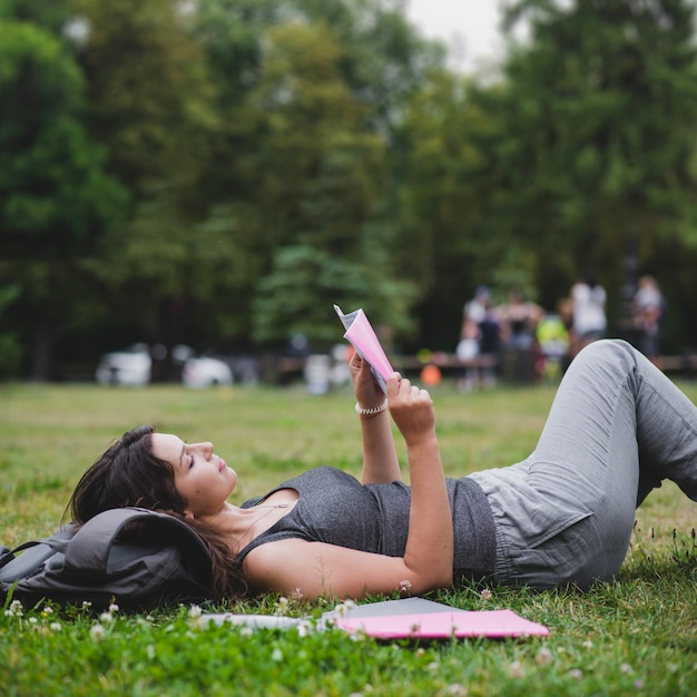 Dziewczyna leży na trawie w parku czytania