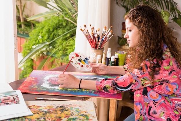 Dziewczyna maluje kanwę w pracowni artystycznej