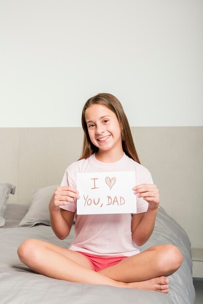 Dziewczyna na łóżku z papierem na dzień ojca