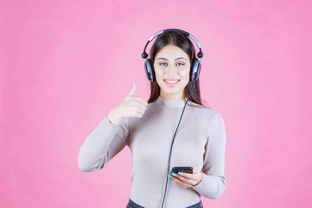 Dziewczyna nosi słuchawki i słucha muzyki