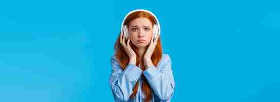 Bezpłatne zdjęcie dziewczyna o płaczu z emocjonalnej piosenki zdenerwowana ruda dziewczyna cierpiąca na zerwanie szlochająca słuchająca muzyki