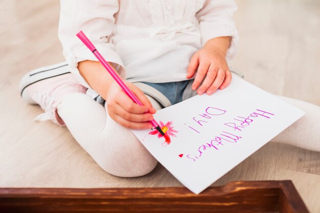 Dziewczyna pisze szczęśliwy dzień matki na papierze