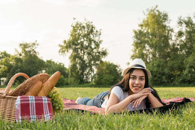 Bezpłatne zdjęcie dziewczyna pozuje na koc piknikowy