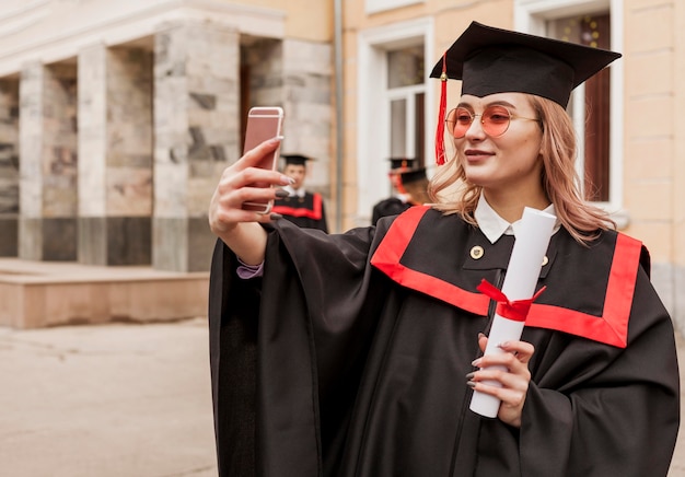 Bezpłatne zdjęcie dziewczyna przy selfie z dyplomem