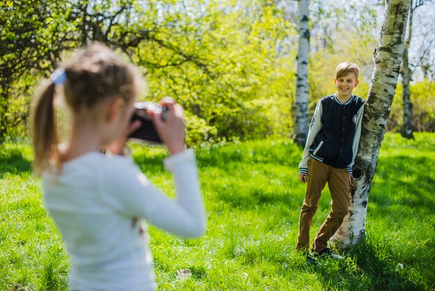 Dziewczyna przy użyciu aparatu fotograficznego w parku