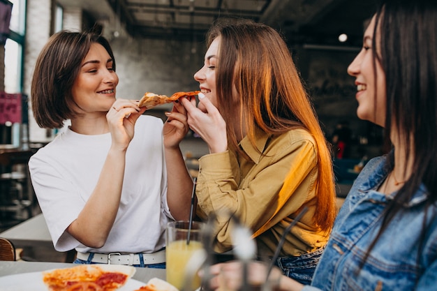 Dziewczyna przyjaciele ma pizzę przy barem przy lunchu czasem