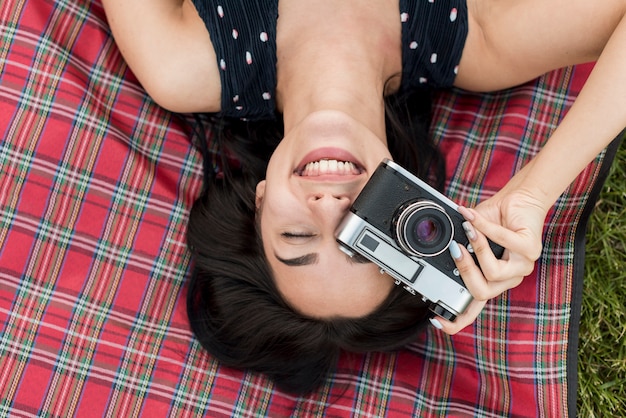 Bezpłatne zdjęcie dziewczyna robi fotografii na koc piknikowy