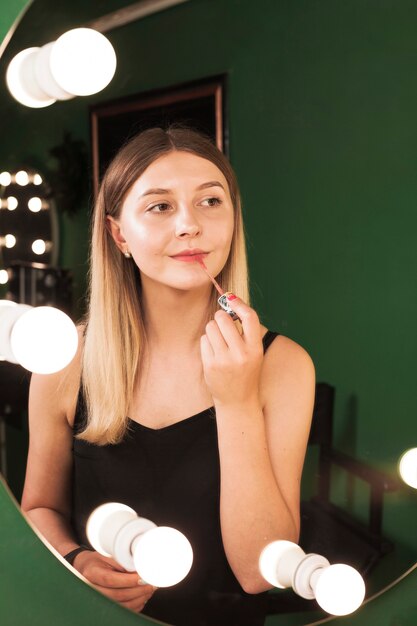 Dziewczyna robi jej makijaż w zielonym pokoju