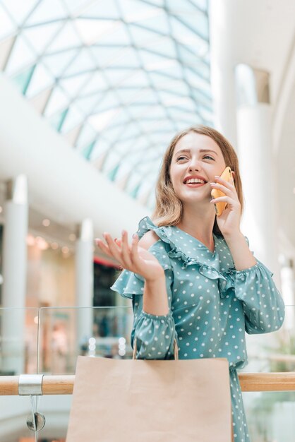 Dziewczyna rozmawia przez telefon w centrum handlowym